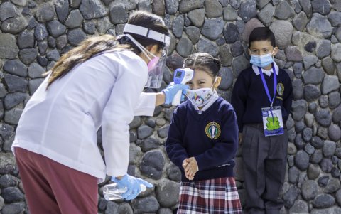 Las maestras son las encargadas de tomar la temperatura a los niños antes de que ingresen a las instalaciones del plantel.