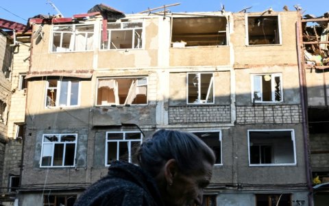 Una anciana camina frente a un edificio de viviendas, damnificado en los recientes bombardeos en Stepanakert.