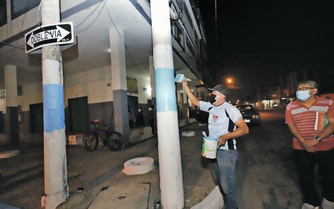 Un grupo de vecinos del Barrio Garay pintan postes y veredas por la celebración de los 200 años de la Independencia de Guayaquil.