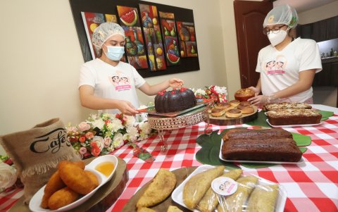 Las jóvenes emprendedoras, acomodan la mesa, luego de preparar los dulces.