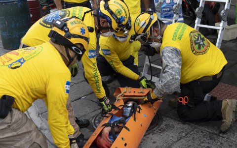 Rescue workers evacuate a mock victim during an earthquake drill at the historic center of San Salvador on October 26, 2020. - Civil protection authorities and the Ministry of the Interior led a simultaneous drill in different major cities of El Salvador to commemorate the 34th anniversary of the earthquake of October 10, 1986, which left over 3,000 dead and several buildings collapsed. (Photo by Yuri CORTEZ / AFP)