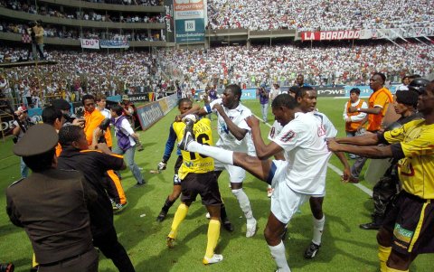 El jugador del Barcelona, Leonardo Soledispa, intenta defenderse de los golpes de los jugadores de la Liga de Quito.