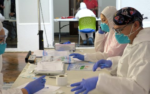 Unos técnicos de laboratorio empaquetan en bolsas de plástico las pruebas del coronavirus realizadas en San Juan.