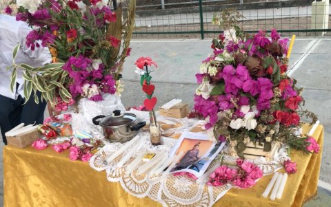 En una mesa se colocaron las fotografías junto a las velas y a las flores.