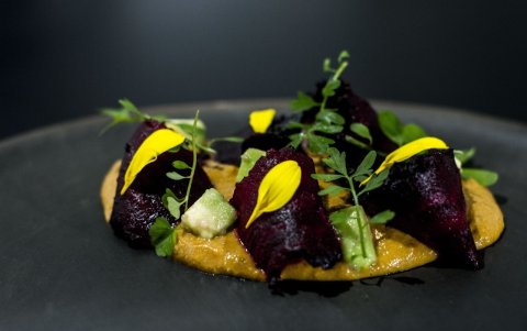 Betarraga rostizada, salsa cremosa de tomate y maní, aguacate, flores y yerbas de recolección.