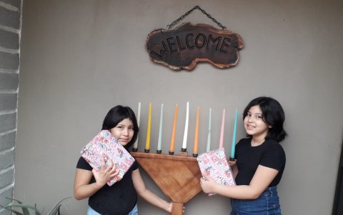 Niñas recibiendo regalos por Janucá.