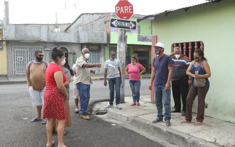 Guillermo Leones, en el centro, levanta su brazo para señalar las cuadras que se deben caminar hasta la estación de la Metrovía, si no hay suficientes alimentadores.