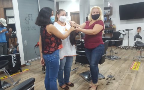 Marvelys y su madre, Lourdes Zambrano (der.) entregan el cabello donado a Jéssica Camejo (centro), de la fundación Fuerza Dorian.