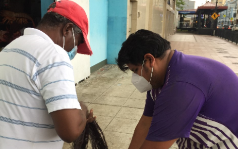 Atención. El comerciante entrega una red a un pescador en la calle Eloy Alfaro.