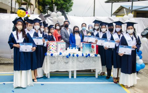 Las nuevas graduadas muestran el título recibido.