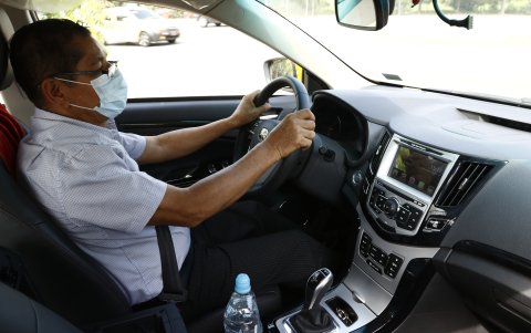 El taxista Oswaldo Tarari conduce un carro eléctrico por las calles de Guayaquil.
