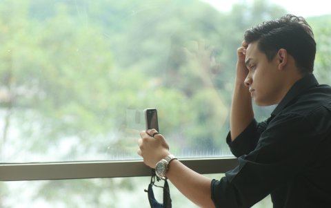 Soltería. Roy Ronquillo, en una suite del hotel Radisson, busca en una agenda un evento que le permita ampliar su círculo de amistad; pero no hay opciones.