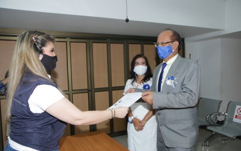 La abogada Catherine Maridueña entrega el acta de casados a los esposos Romero Chacón.