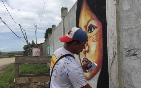 El artista Jorge Guaranda realiza los trazos con el pincel formando la figura ancestral de acuerdo al proyecto, solicitada por los comuneros de la localidad.