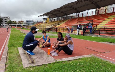 Las atletas en una pausa escuchan al entrenador Nelson Gutiérrez.