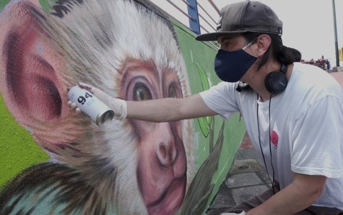 El pintor Andrés Franco reconocido en el mundo del arte como Andy Son da retoques al mural que hizo junto a 10 niños que tienen diversos tipos de discapacidades.
