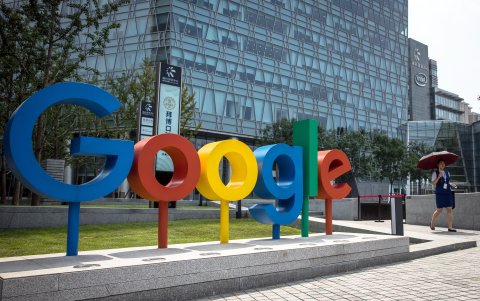 Fotografía de archivo fechada el 3 de agosto de 2018 que muestra a una mujer que camina junto al logo de Google, en las oficinas de dicha firma en Pekín (China).