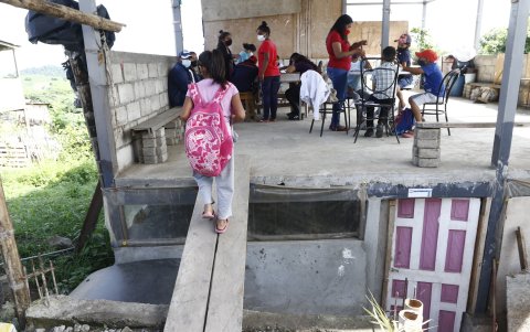 Un ‘puente’ de tabla lleva a una niña a una ‘escuela improvisada en Monte Sinaí.