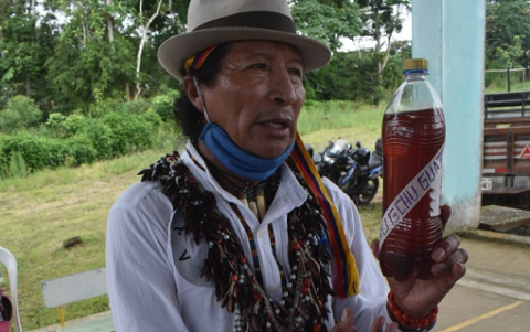 Bebida. El chamán muestra en una botella el brebaje de plantas nativas.