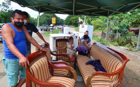 Las familias damnificadas sacaron sus enceres a un lado de la carretera.