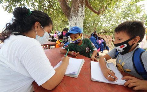 Hasta debajo de un árbol los niños recibieron ayuda escolar, debido al cierre de las escuelas, por la pandemia.