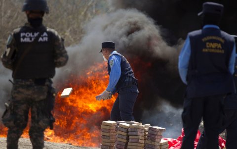 Tegucigalpa. Un policía hondureño tira un alijo de cocaína a las llamas donde se destruyeron 1426 kilos de droga incautada por las autoridades en diferentes operaciones en febrero.