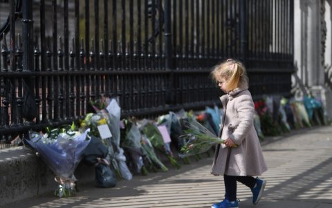 Una niña se acerca a dejar flores a la puertas del Palacio de Buckingham de Londres, en recuerdo del fallecido duque Felipe de Edimburgo.