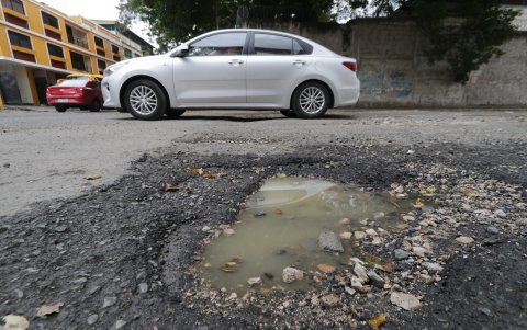 Los ‘cráteres’ en la calzada se han convertido en un peligro para los peatones y conductores.