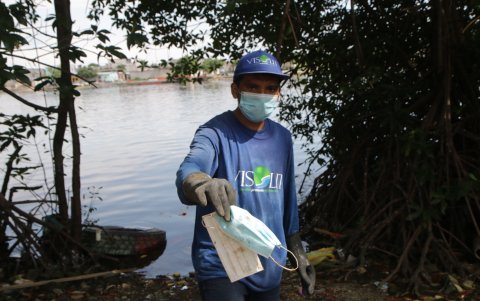 Afectación. Hasta las aves de corral salen afectadas. En la foto, una de ellas trata de tener un festín con los desechos botados a la orilla del estero. Entre la basura hay guantes y mascarilla.