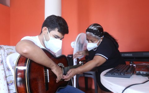 Música. Josué Mieles es un joven no vidente y tiene autismo. Su mamá, Nancy Mite, sin ser profesora y sin saber de música, le indica que cuerdas debe hacer sonar y los acordes.