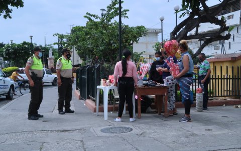 La Policía Nacional pide a una comerciante informal que retire su puesto, porque solo se puede vender con entrega a domicilio, ya que hay toque de queda.