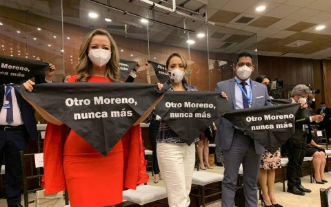 Legisladores de UNES exponen pañuelos negros con una frase en contra del presidente saliente, Lenín Moreno.