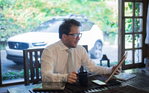 Mientras trabaja en su oficina, acompañado de una taza de café.