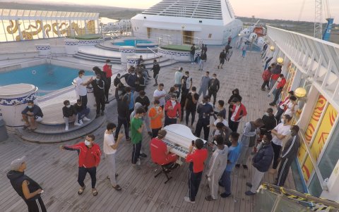 Los migrantes se reúnen en la proa del barco.