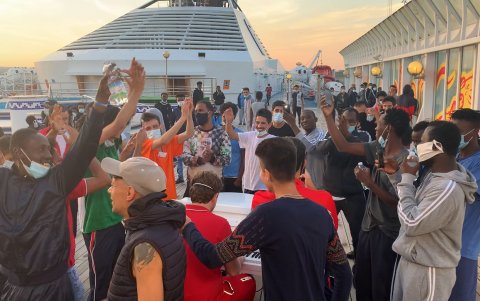 Los migrantes brindan y bailan alrededor de Francesco y su piano.