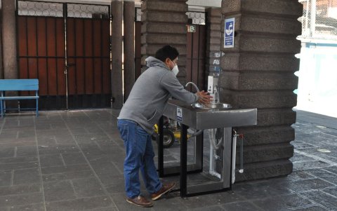 Constatación. Carlos Cueva verifica que los lavamanos al ingreso de una de las cuatro entradas de la escuela Sucre funcionan correctamente.