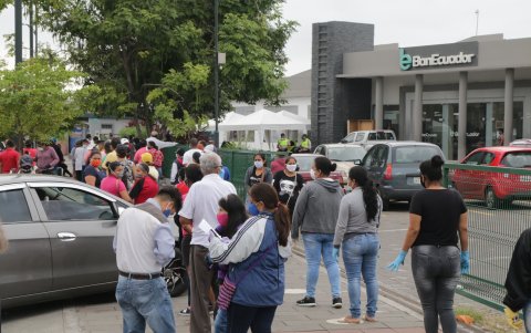 Ayuda. Decenas de personas hacen fila en los exteriores de BanEcuador con el fin de cobrar el bono.
