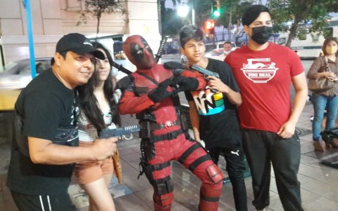 El venezolano Alberto Hurtado, enfundado en un traje de Deadpool, posa junto a una familia guayaquileña.