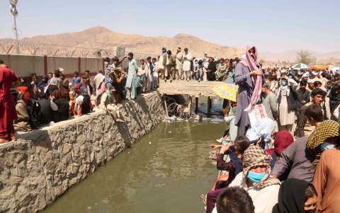 Afganos tratan de acceder al Aeropuerto Internacinal Hamid Karzai de Kabul, Afganistán, en busca de ayuda.