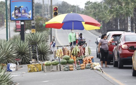 A lo largo de la avenida Orellana, en el norte de la ciudad, se observan algunos tramos de gran tráfico vehicular y la luz roja da paso al desfile de quienes intentan salir adelante en las calles.