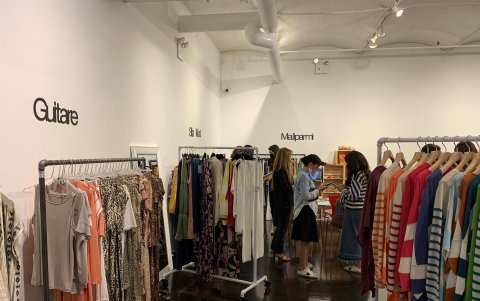 Varias personas miran los diferentes diseños de las marcas participantes en la feria FashionLab Market hoy viernes en Nueva York.