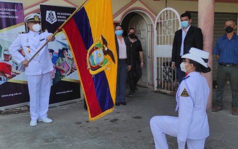 Nayeli Rodríguez, abanderara de la Academia Naval Guayaquil se inclina ante la bandera nacional para rendirle homenaje.
