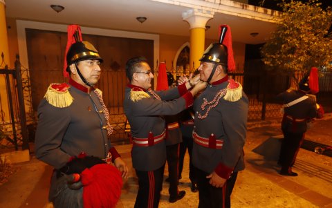 Camaradería.- Los exalumnos de la banda de guerra del colegio Eloy Alfaro unos a otros se arreglan el casco.
