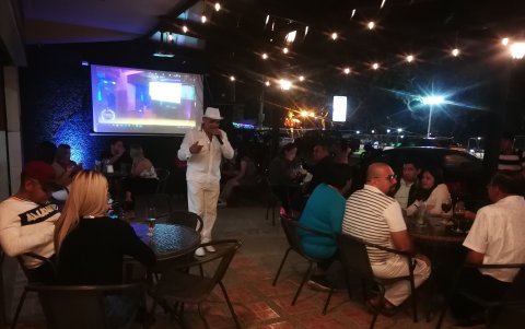 Un grupo de turistas en Playas disfruta de una presentación artística en un espacio abierto.
