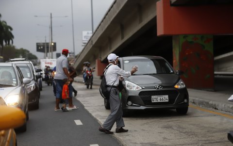 Con un gesto un peatón busca que un conductor reduzca la velocidad en la Francisco de Orellana, aun cuando el semáforo está en verde. En el lugar incluso se ve a peatones arrastrando quioscos de comida de un lado de la vereda a otro, causando más embotellamientos.