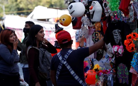 Grupos de personas observan un puesto ambulante con máscaras de Halloween, el 26 de octubre de 2021, en la Ciudad de México (México).