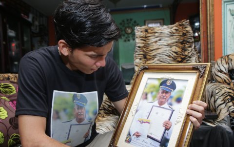 Nostalgia. Rodolfo Peña simula un contacto visual con una fotografía de su padre. Señala estar orgulloso de las condecoraciones que recibió en la Comisión de Tránsito.