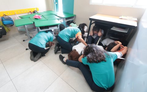 Los niños se lanzan al piso y se esconden para no ser vistos desde afuera.