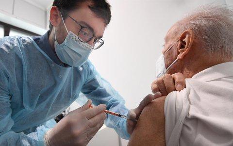 Un farmaceútico administra a un anciano la tercera dosis de la vacuna anticovid de Pfizer-BioNTech en Milan, Italia.