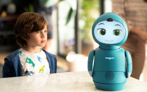 Un niño juega y aprende con el robot Moxie.